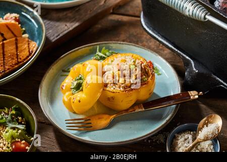 Poivre sucré entier grillé avec couscous ou quinoa et farce de légumes mélangés servis sur une assiette comme plat ou apéritif Banque D'Images