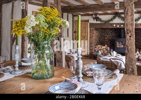 Couper des fleurs et de grandes bougies sur la vieille table de ferme en pin Banque D'Images