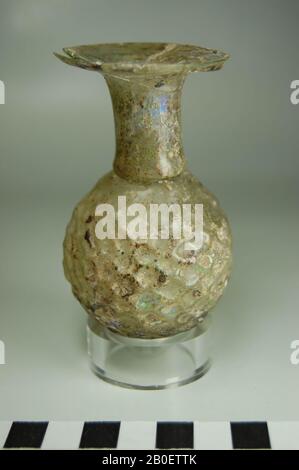 bouteille, arroseur, arroseur de parfum soufflé ou compte-gouttes de verre transparent décoloré. La bouteille a un corps sphérique avec un motif nid d'abeilles en relief. La pièce est soufflée dans un moule à deux pièces, la malnaade est encore vaguement visible. Le cou est cylindrique et s'étend dans une lèvre plate en forme de disque avec un bord arrondi. Sur la transition de l'épaule au cou, un rétrécissement est fourni à l'intérieur, créant une petite ouverture ronde pour les parfums de goutte, la bouteille, le verre, le soufflage de moule, par exemple. 8,8 cm, diam. 5,2 cm, Période gréco-romaine, âge impérial romain du 3ème siècle, Egypte Banque D'Images