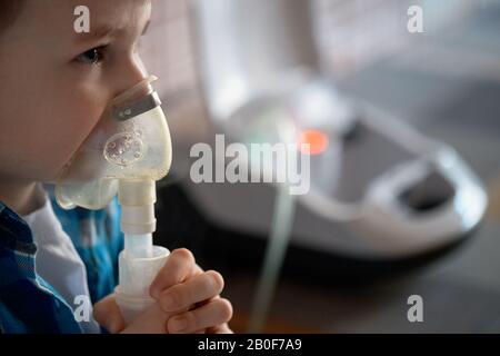 L'inhalation enfant fait à la maison avec le nébuliseur hors focale arrière-plan. Exemple de la lutte contre les maladies respiratoires comme la bronchite trachéite pneu Banque D'Images