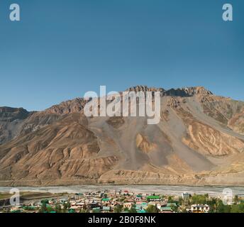 Vue élevée de la ville de Kaza avec la rivière et l'Himalaya en arrière-plan sur un beau matin d'été sous le ciel bleu dans l'Himachal Pradesh, Inde. Banque D'Images