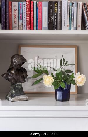 Fleurs et livres frais avec statue et œuvres d'art Banque D'Images