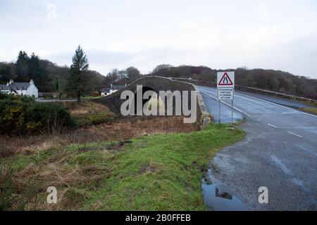 Le pont de Clachan est un pont à dos de bosse qui relie la côte ouest du continent écossais à l'île de Siel à Argyll et Bute. Banque D'Images