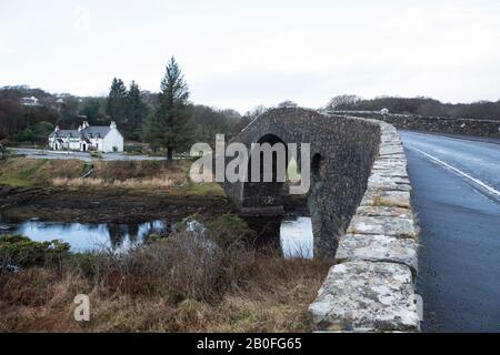 Le pont de Clachan un pont à dos d'hump reliant la côte ouest du continent écossais à l'île de Siel avec le célèbre Tigh an Truish Inn Banque D'Images