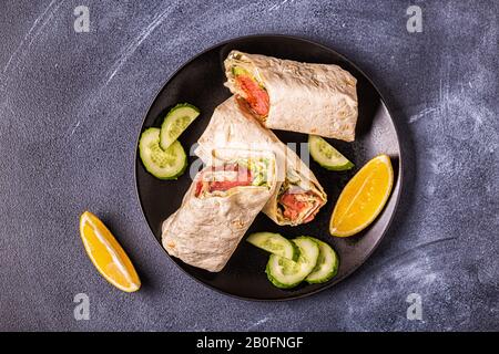 Sandwich emballé avec saumon, laitue, concombre et fromage à la crème, vue de dessus. Banque D'Images