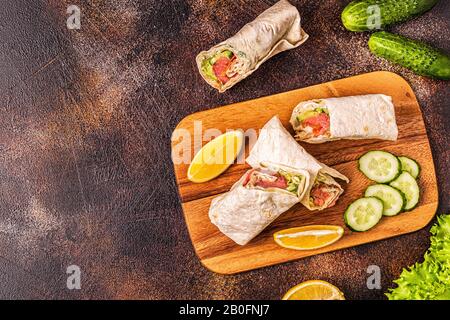 Sandwich emballé avec saumon, laitue, concombre et fromage à la crème, vue de dessus. Banque D'Images