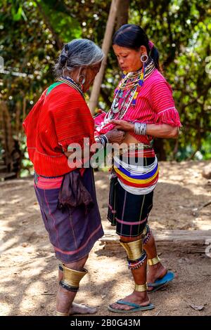 Une Jeune Femme Du Groupe Ethnique Kayaw Donnant De La Nourriture À Une Femme Âgée, Htay Kho Village, Loikaw, Myanmar. Banque D'Images