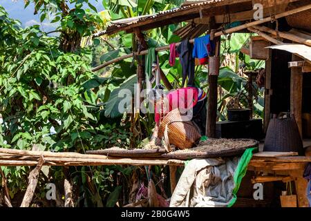 Une Femme Du Groupe Ethnique Kayaw Travaillant À L'Extérieur De Sa Maison, Htay Kho Village, Loikaw, Myanmar. Banque D'Images