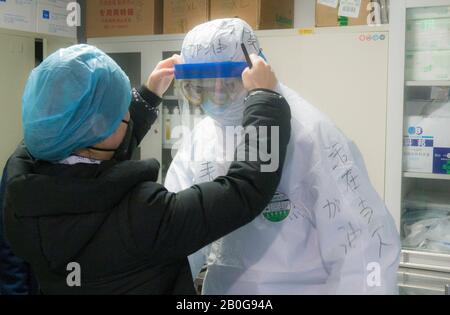 Wuhan, La Province Chinoise De Hubei. 20 février 2020. Un travailleur médical de l'hôpital Affilié de l'Université de Qingdao met un masque facial pour un collègue de la région de Guanggu de l'hôpital Tongji de Wuhan à Wuhan, dans la province de Hubei en Chine centrale, le 20 février 2020. Afin de mieux protéger les travailleurs médicaux, certaines mesures de prévention ciblées et précises sont strictement prises pendant le temps de travail et le temps de congé par le personnel médical de l'hôpital Affilié de l'Université de Qingdao qui sont à Hubei pour aider à la lutte contre le virus. Crédit: Cai Yang/Xinhua/Alay Live News Banque D'Images