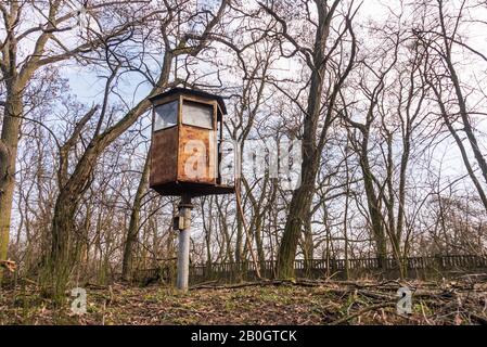 Une vieille tour de guet militaire rouillée située dans les bois. Au début du printemps, arbres sans feuilles et tour d'observation des métaux. Banque D'Images