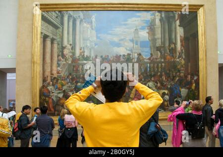 Homme prenant la photo du mariage à Cana , les Noces de Cana par Paolo Veronese à l'intérieur du musée du Louvre, Paris, Ile de France, France Banque D'Images