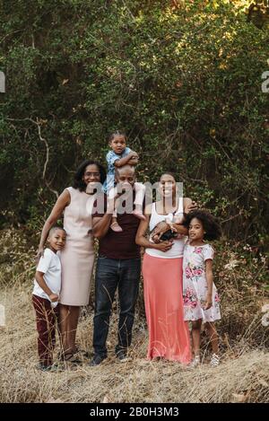Portrait de famille élargie multigénérationnelle souriant sur le terrain Banque D'Images