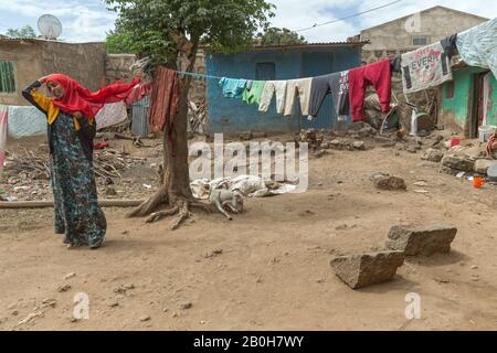 07.11.2019, Adama, Oromiyaa, Ethiopie - une femme voilée se tient dans la cour d'un complexe simple et pauvre. Dans le vent le voile souffle. Femmes A Banque D'Images