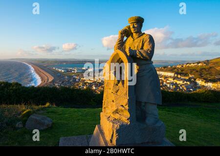 Fortuneswell, Portland, Dorset, Royaume-Uni. 20 février 2020. Météo britannique. L'Esprit de sculpture de Portland qui se trouve au-dessus de Fortuneswell sur l'île de Portland à Dorset illuminé par le soleil de fin d'après-midi avec vue sur Fortuneswell et Chesil Beach. Crédit Photo : Graham Hunt/Alay Live News Banque D'Images