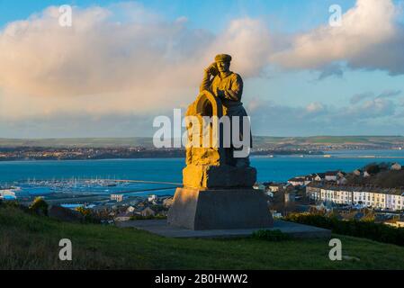 Fortuneswell, Portland, Dorset, Royaume-Uni. 20 février 2020. Météo britannique. L'Esprit de sculpture de Portland qui se trouve au-dessus de Fortuneswell sur l'île de Portland à Dorset illuminé par le soleil de fin d'après-midi avec vue sur Fortuneswell derrière lui. Crédit Photo : Graham Hunt/Alay Live News Banque D'Images