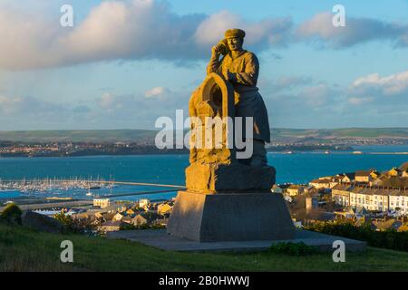 Fortuneswell, Portland, Dorset, Royaume-Uni. 20 février 2020. Météo britannique. L'Esprit de sculpture de Portland qui se trouve au-dessus de Fortuneswell sur l'île de Portland à Dorset illuminé par le soleil de fin d'après-midi avec vue sur Fortuneswell derrière lui. Crédit Photo : Graham Hunt/Alay Live News Banque D'Images