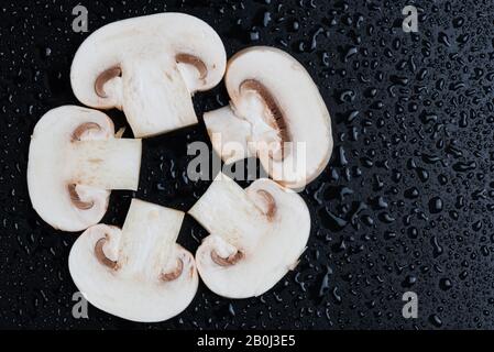 De nombreux champagnes aux champignons frais et gilleux isolés sur fond noir, vue de dessus Banque D'Images