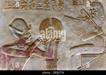 Mur bas-relief représentant le roi Seti I présentant un wesekh doré à Isis dans le Grand Temple d'Abydos Banque D'Images