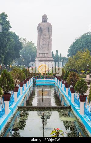 Grande statue de Bouddha debout dans le temple thaïlandais WAT, Sarnath ville près de Varanasi, Inde Banque D'Images