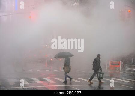 La vapeur monte et dévie au-dessus de l'Avenue parmi les bâtiments de Midtown Manhattan lors de la journée de neige autour De Times Square à New York City NY USA en janvier 2020. Banque D'Images