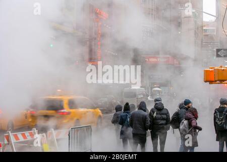 La vapeur monte, dévie l'intersection de la route entre les bâtiments de Midtown dans la neige à La Times Square à New York City NY USA le 18 janvier 2020. Banque D'Images
