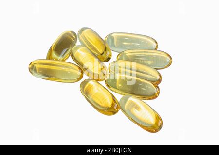 Capsules dorées d'Omega 3 sur fond blanc. Banque D'Images