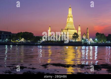 Spectaculaires couchers de soleil au-dessus du monument bouddhiste Wat Arun Temple de l'aube reflété dans la rivière Chao Phraya dans la ville de Bangkok, Thaïlande Asie du Sud-est Banque D'Images