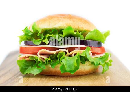 Sandwich frais avec légumes et jambon sur la planche en bois isolé sur fond blanc Banque D'Images