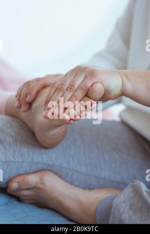 Massage des pieds thaïlandais à la main. Médecine alternative et massage thaïlandais concept Banque D'Images