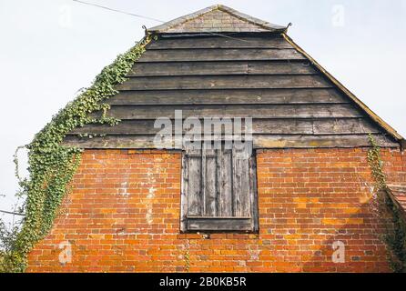 Extrémité ouest de la vieille grange agricole avec ancienne porte d'accès à l'étage supérieur pour stocker les cultures pendant l'hiver au début du XXe siècle dans le Wiltshire Banque D'Images