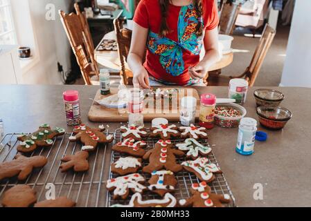 Les filles mettent les prinkles sur les biscuits de Noël Banque D'Images