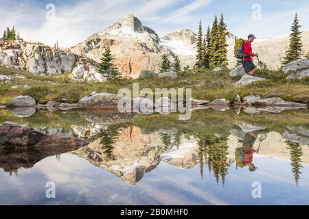 Vue latérale et reflet de randonnée en randonnée en randonnée à côté du lac alpin. Banque D'Images