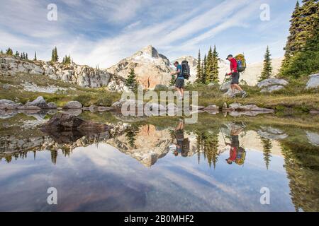 Vue latérale et reflet des routards randonnée à côté du lac alpin. Banque D'Images
