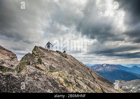 Deux grimpeurs approchent du sommet d'un sommet de montagne. Banque D'Images