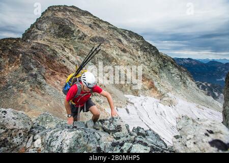 Vue en grand angle de l'escalade d'un routard dans une montagne rocheuse. Banque D'Images