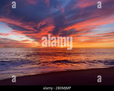 Les spectateurs ont une perspective de coucher de soleil sur l'océan, qui se reflète dans les nuages Banque D'Images