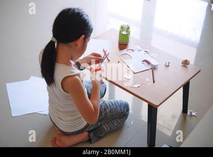 Une fille assise et faisant de l'artisanat Banque D'Images