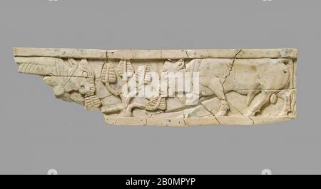 Plaque de meuble sculptée en relief avec des taureaux et des arbres, assyrienne, néo-assyrienne, Date CA. 9–8ème siècle C.-B., Mésopotamie, Nimrud (ancien Kalhu), assyrienne, ivoire, 1,61 x 5,98 x 0,24 po. (4,09 x 15,19 x 0,61 cm), Grugeages ivoire/os Banque D'Images