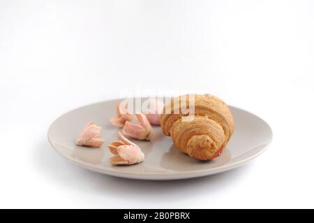 Croissant aux fleurs décorées avec vue horizontale sur la plaque grise Banque D'Images