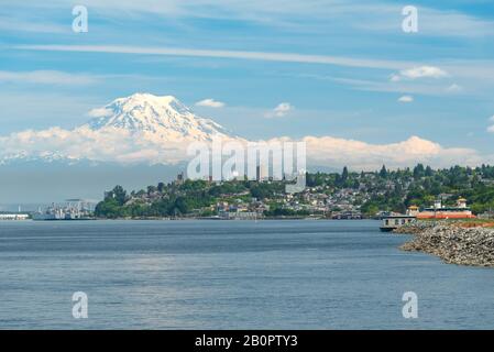 Mt Rainier plane sur le centre-ville de Tacoma et baie de lancement comme vu du point Ruston avec personnes à pied et faire du vélo Banque D'Images