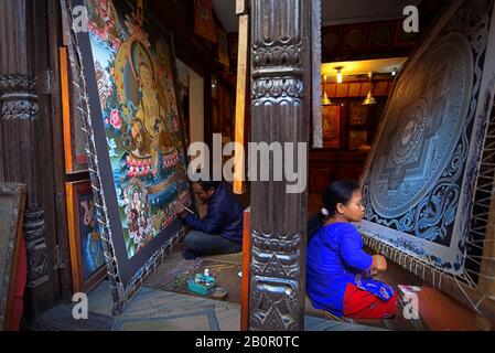 Homme et femme créant thangka (peinture bouddhiste tibétaine) dans une boutique de peinture dans la zone touristique de Bhaktapur, Népal. Banque D'Images