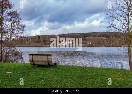 Banc confortable dans un pré sur le bord du lac avec forêt et un lac calme dans le Sauerland Banque D'Images