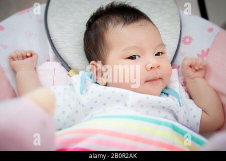 Adorable bébé asiatique coulait pour dormir sur le lit au coucher sur un confortable matelas doux. Banque D'Images