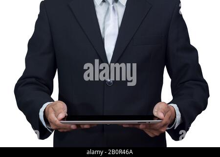 Technologie et concept commercial. Homme d'affaires tenant une tablette numérique isolée sur fond blanc avec chemin de découpe. Jeune adulte travaillant sur un numérique Banque D'Images