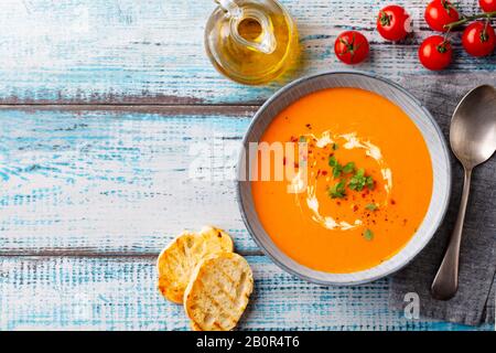 Soupe de citrouille, crème de tomate dans un bol. Fond en bois bleu. Espace de copie. Vue de dessus. Banque D'Images