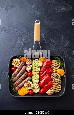 Kebab de viande grillée et légumes dans la poêle à gril. Fond en pierre noire. Vue de dessus. Banque D'Images