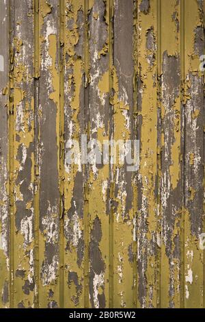 Texture d'un vieux garage perdant la peinture jaune et verte Banque D'Images