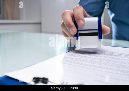 Close-up of Businessman Hand en utilisant Stamper sur le document Banque D'Images