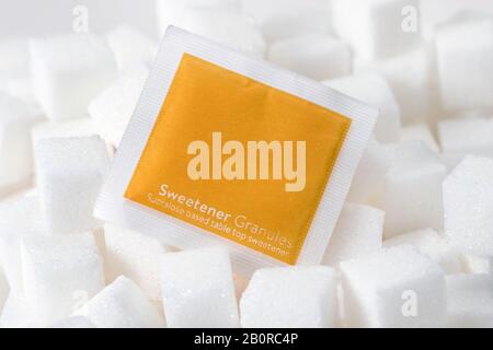 Gros plan macro studio tourné d'un sachet d'édulcorants zéro sucre sur des cubes de sucre blanc Banque D'Images