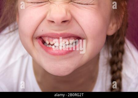 Petite fille montre ses dents. Concept de dents de bébé. Banque D'Images